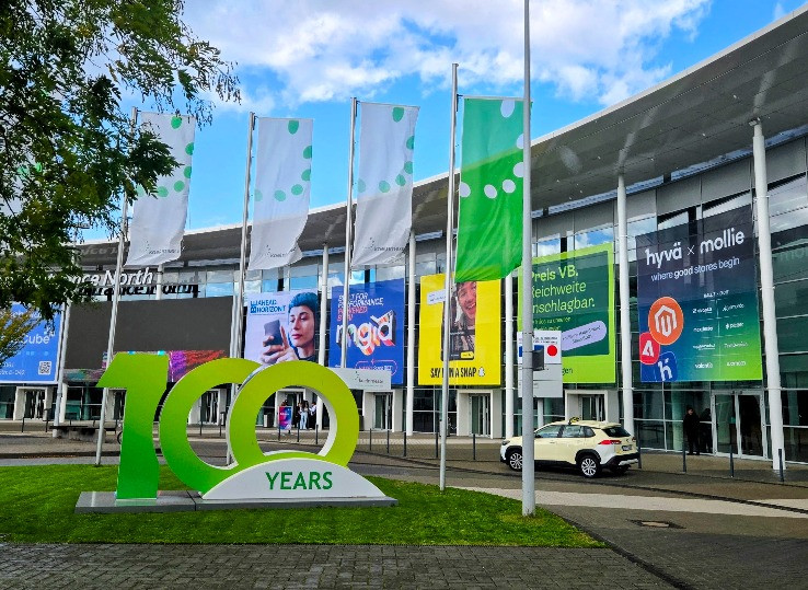 Exterior of an event venue with large banners and a 100 years sign in front. Hyva x Mollie branding visible on the building
