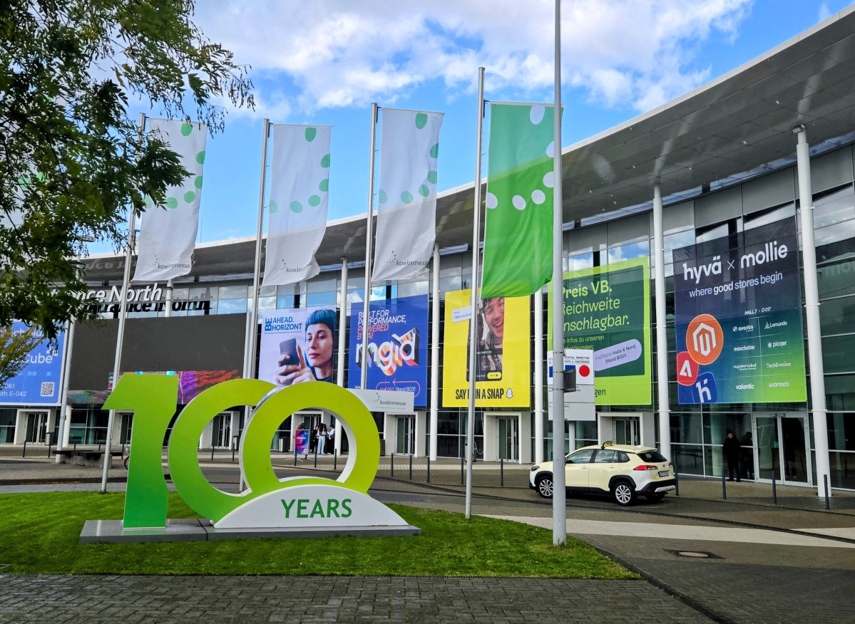 Exterior of an event venue with large banners and a 100 years sign in front. Hyva x Mollie branding visible on the building