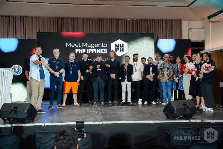Meet Magento Philippines stage scene with speakers and attendees lined up in front of the event main screen.